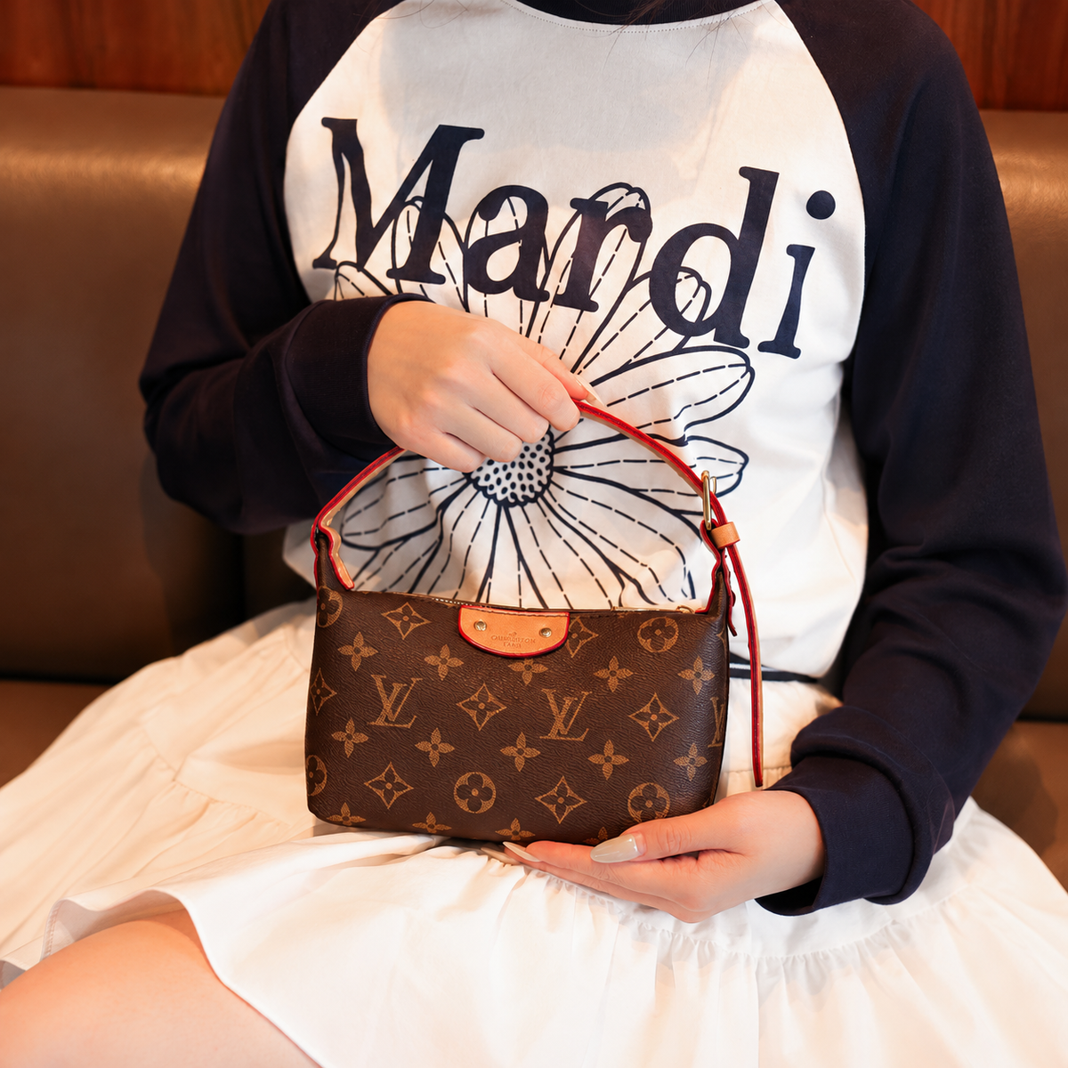 Brown monogram zip shoulder bag held in hand