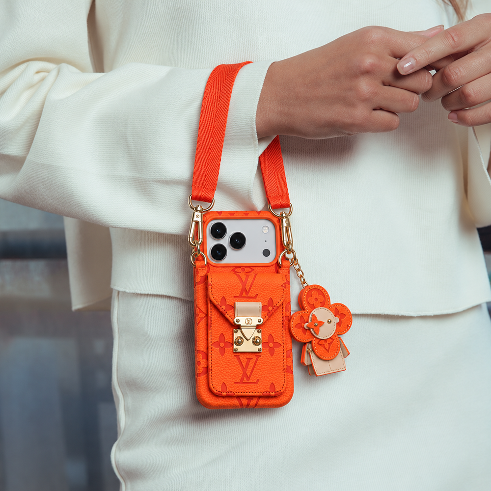 Orange monogram crossbody iPhone case with pocket and flower charm, lifestyle scene 9